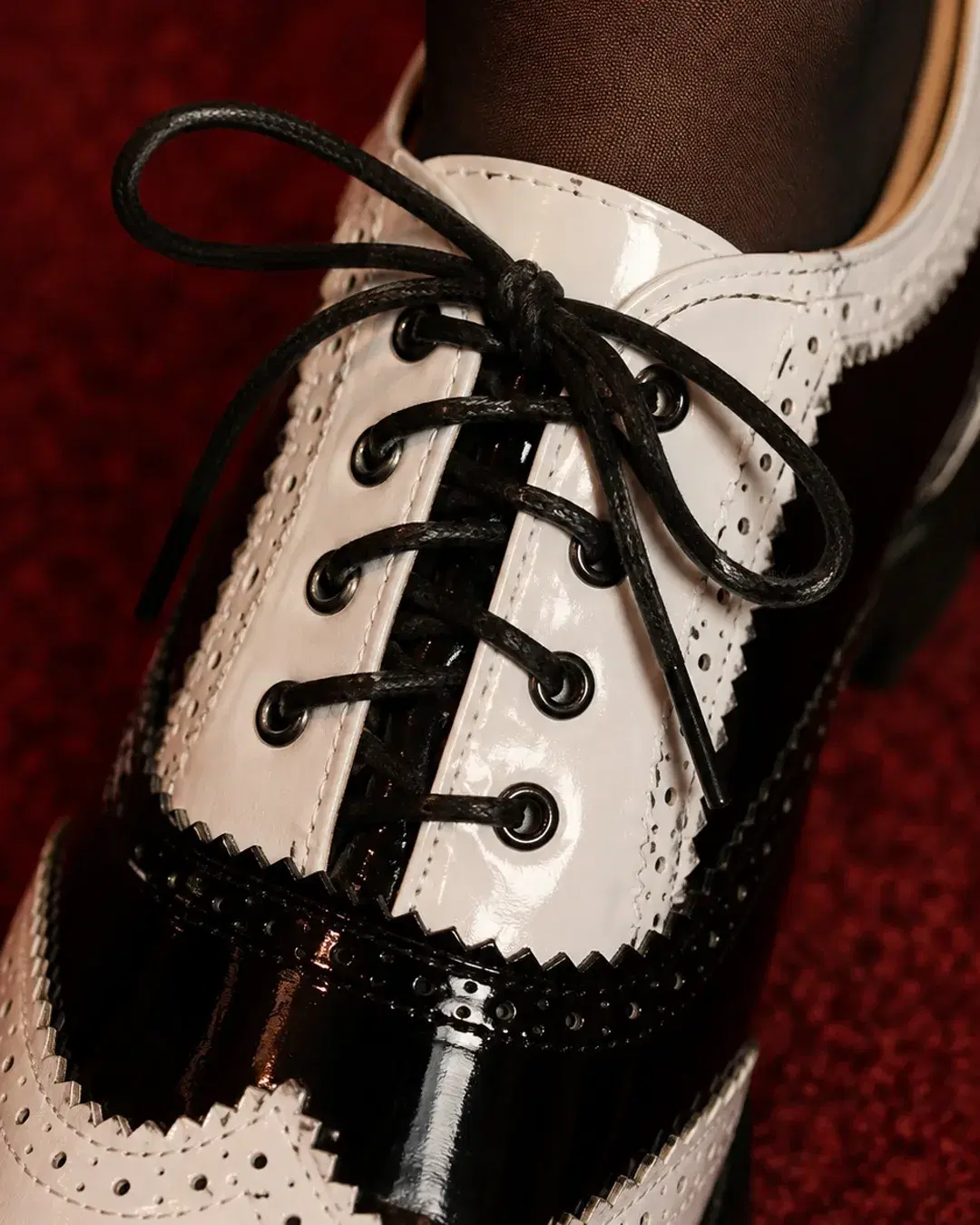 Close view of the lacing, eyelets and the tan lining at the collar