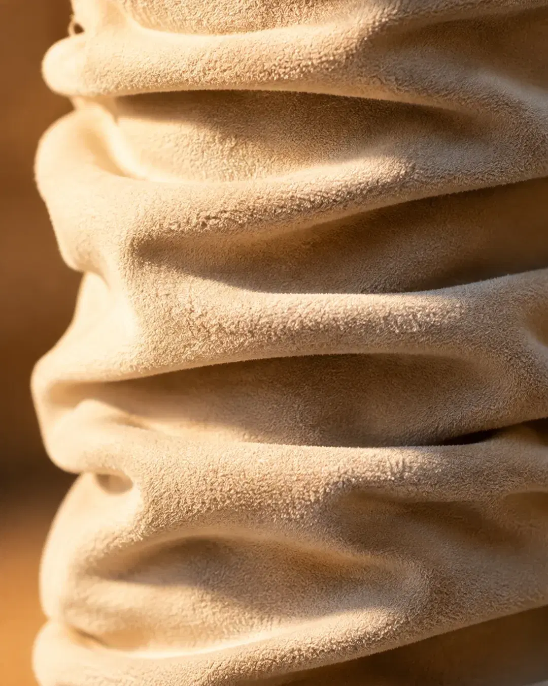 Macro of the gathered folds running down the calf of the boot