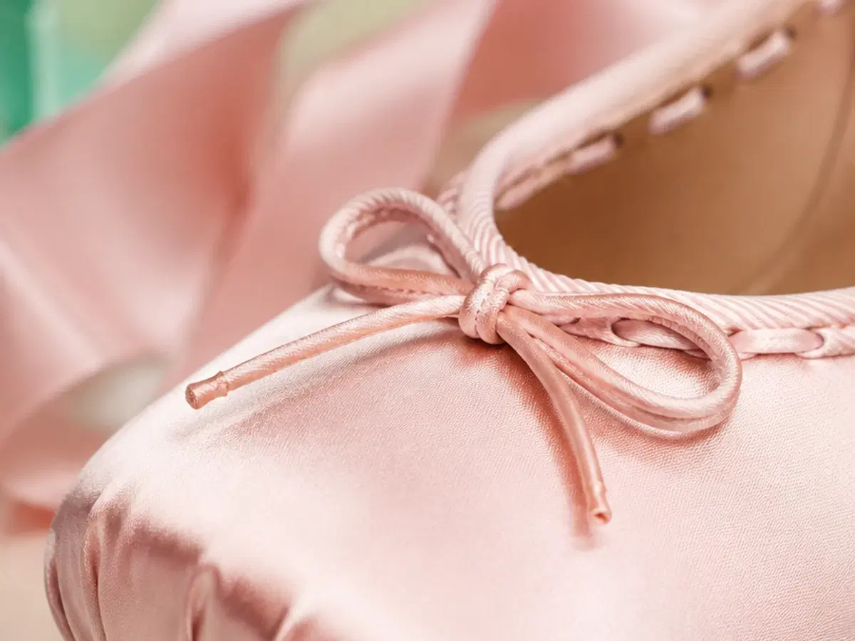 Macro detail of the square gathered toe, flat satin bow and whipstitch topline