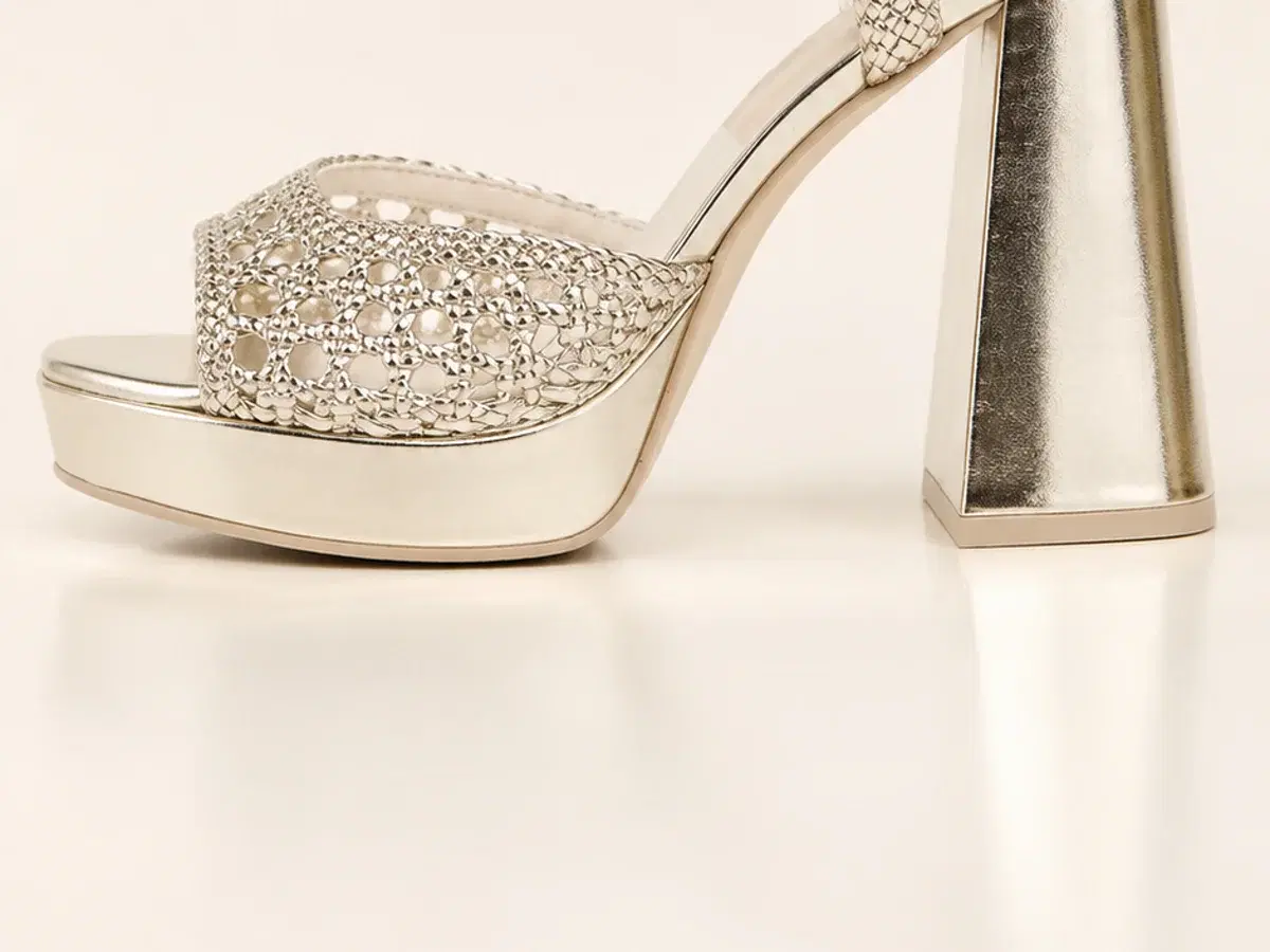 Side profile of the Dolce Vita Peyten showing the flared metallic block heel