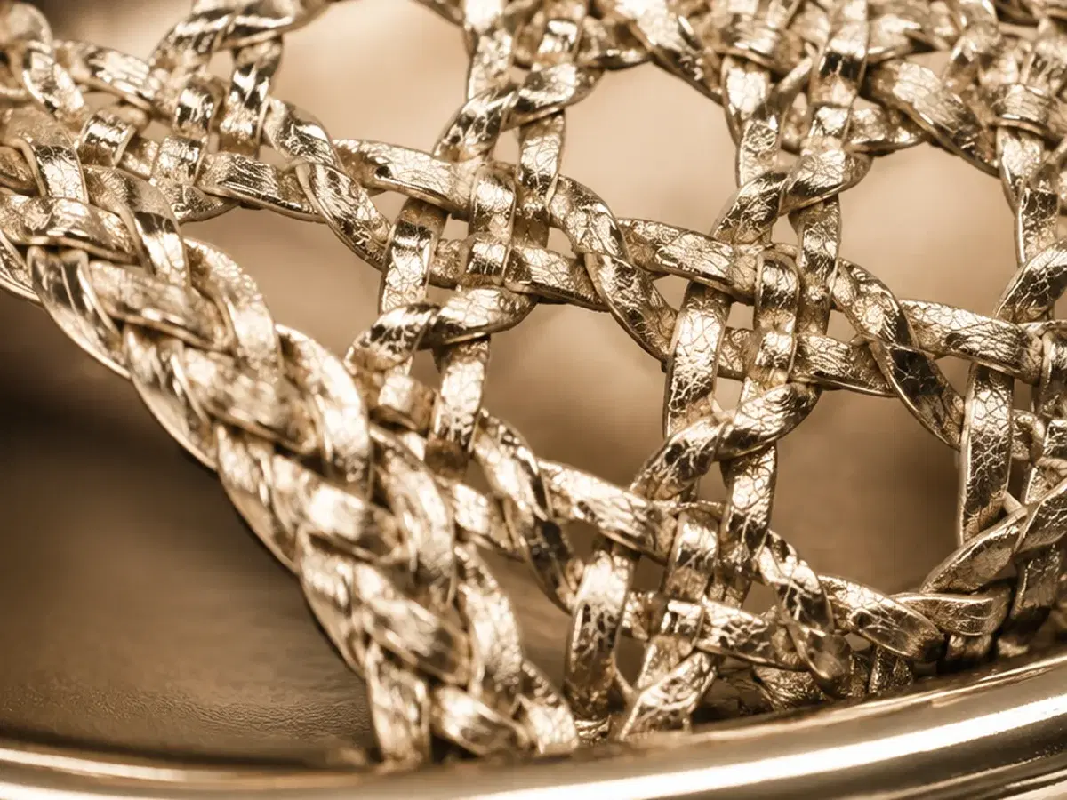 Macro detail of the woven metallic lattice on the Dolce Vita Peyten toe strap