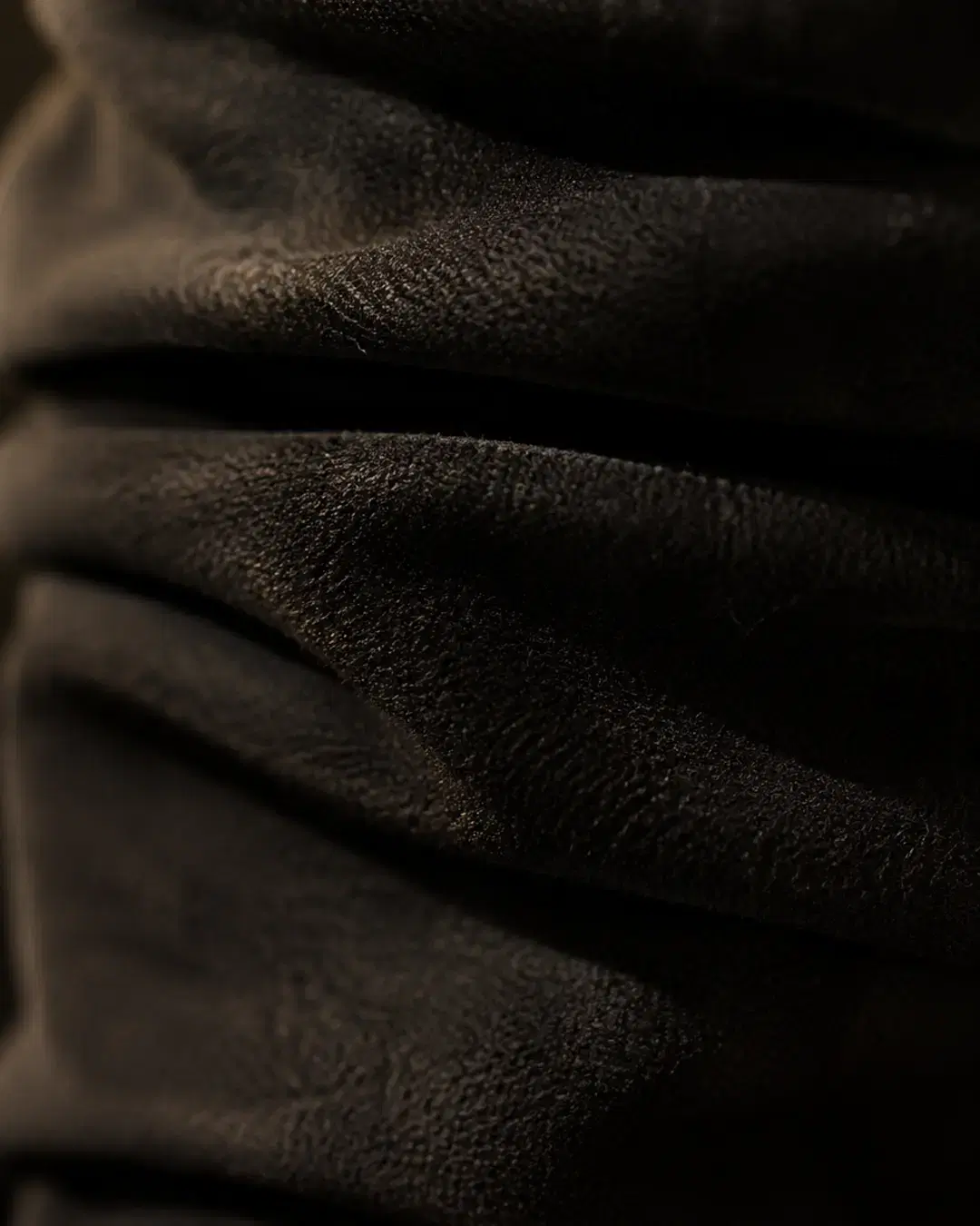 Macro of the ruched faux-suede shaft showing the stacked concertina folds