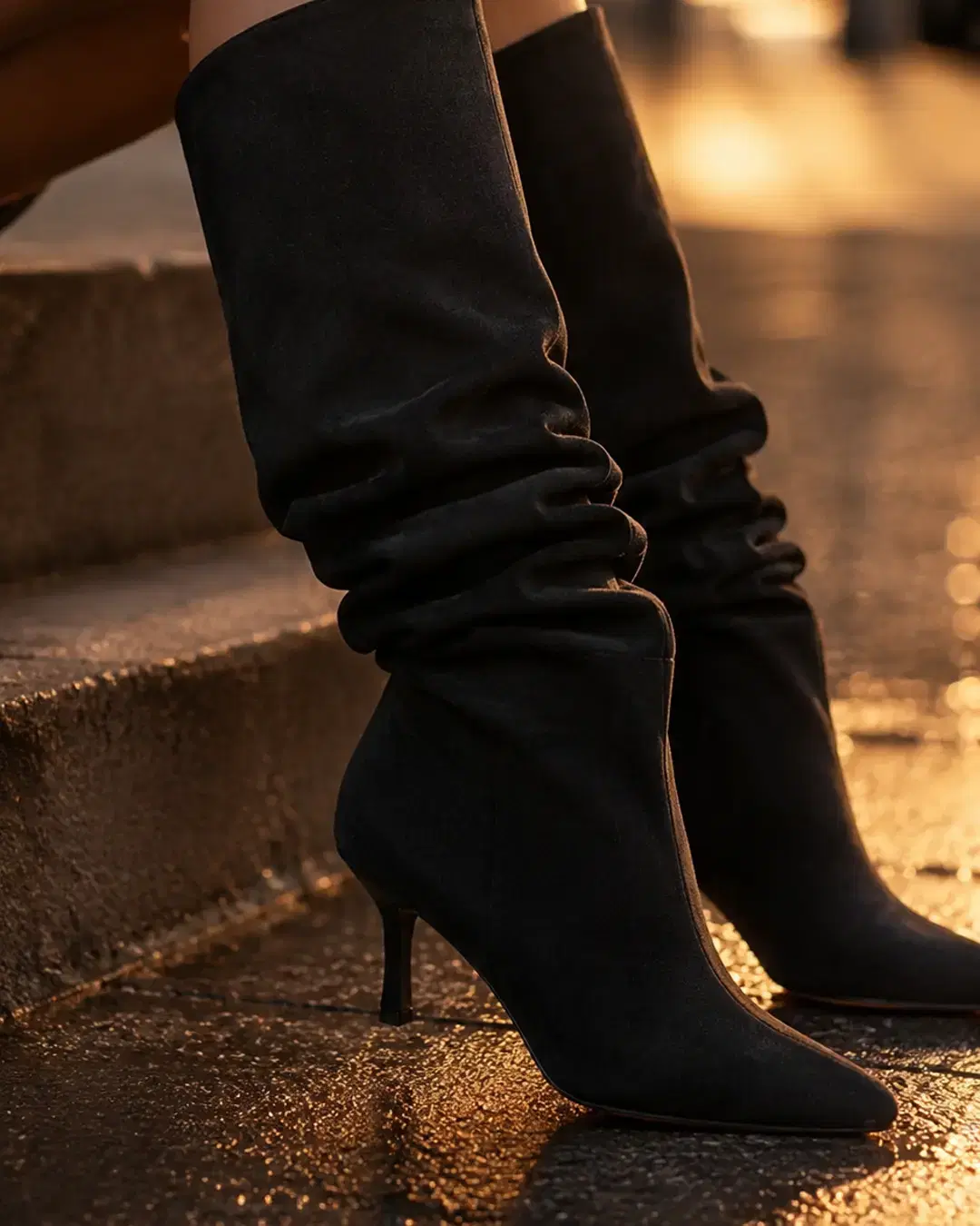 Seated shot with the boot shaft collapsed into deep folds at the ankle