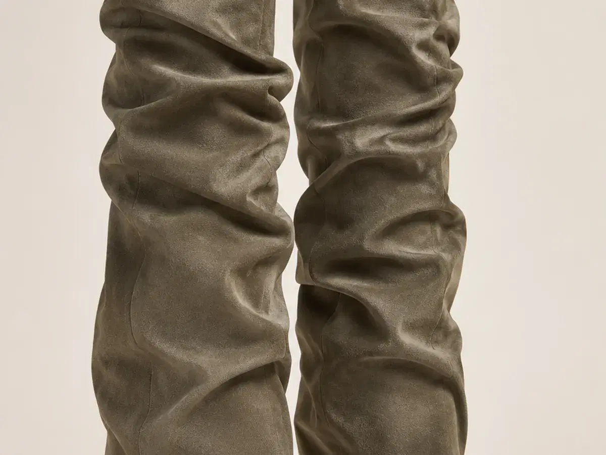 Studio view showing the full silhouette: ruched knee-high shaft over a strappy stiletto sandal