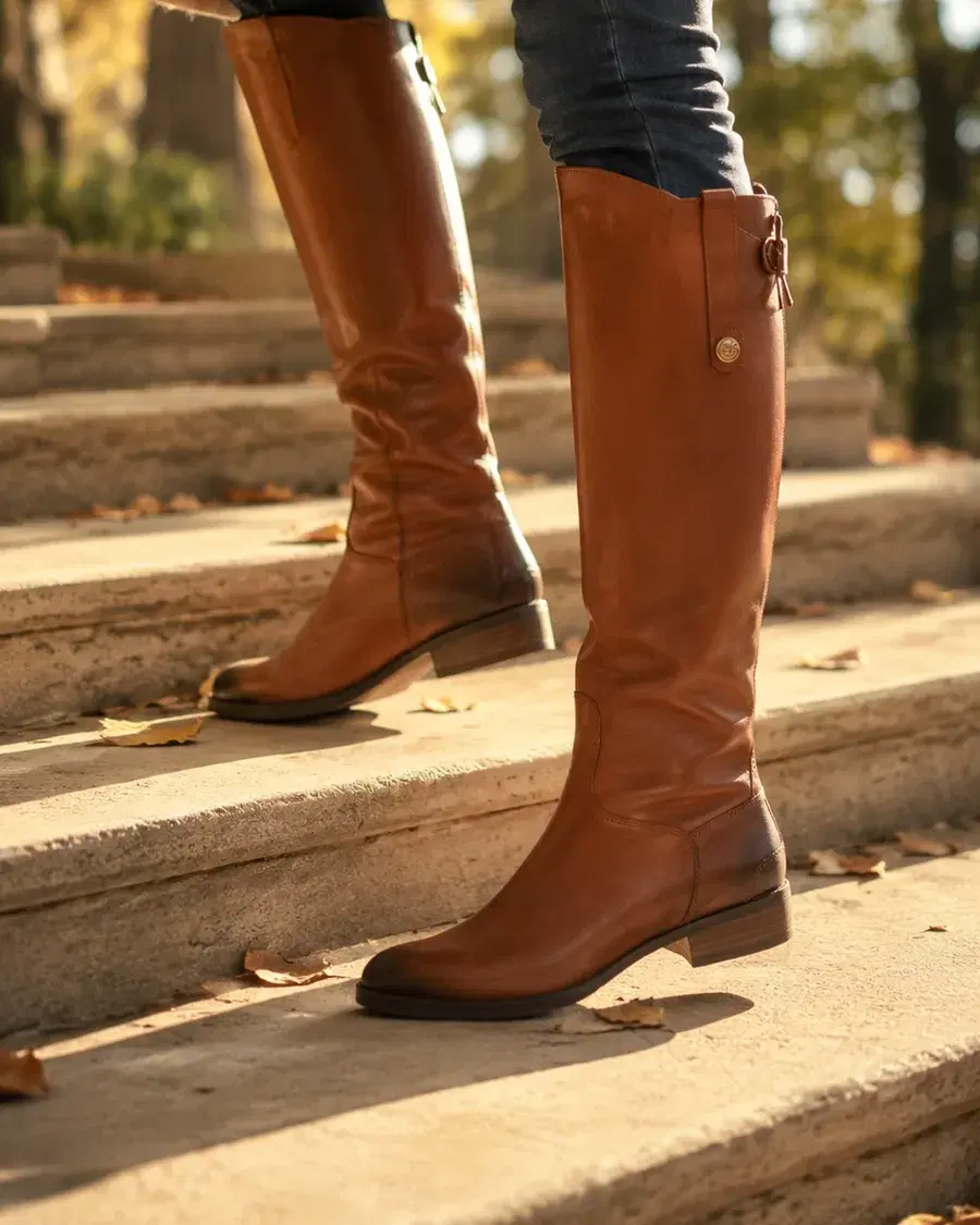 Whiskey riding boots on stone steps in autumn light