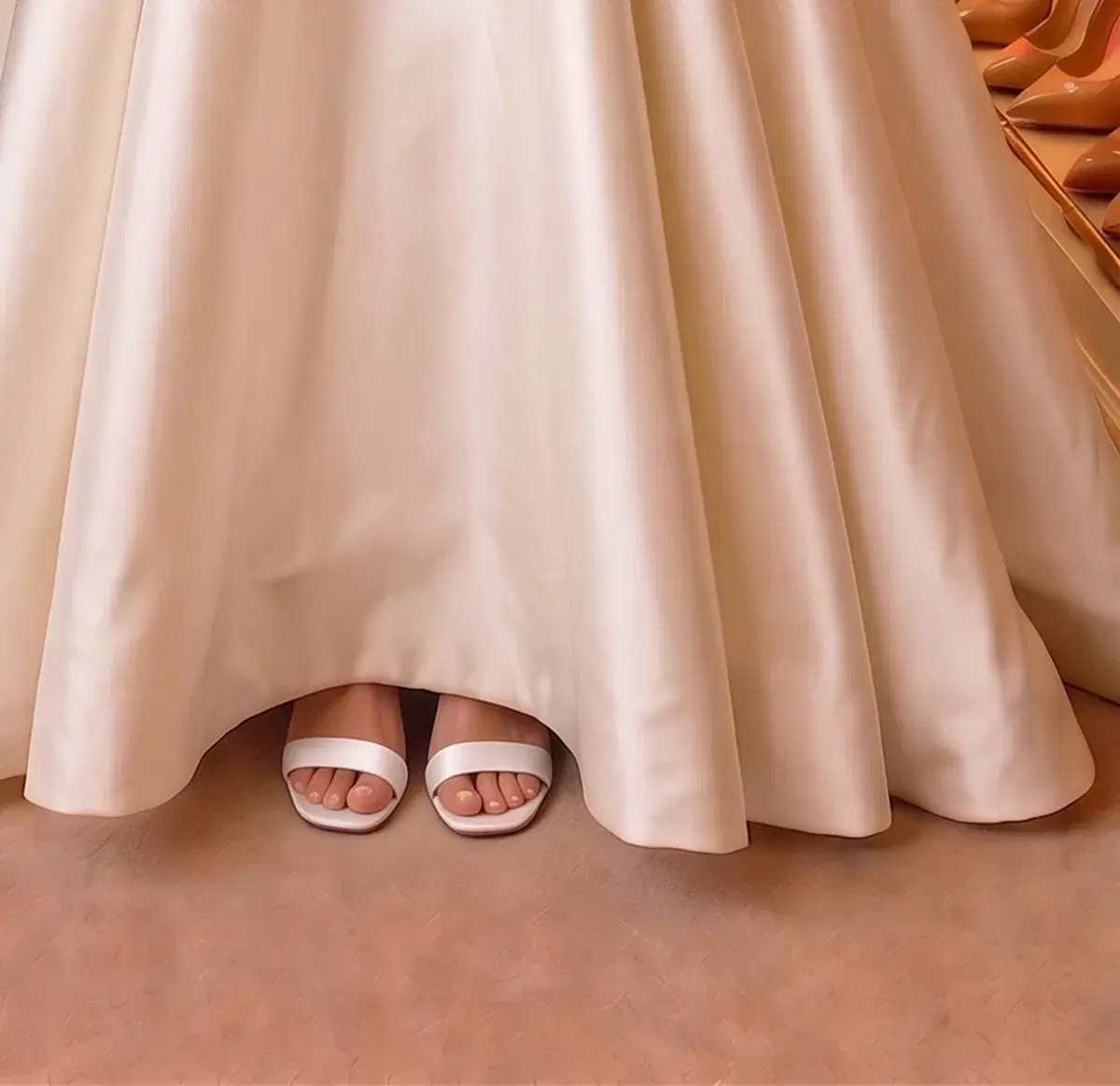 White low block-heel sandals just visible under the ballgown hem